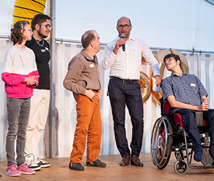 Leiter Ueli Eichholzer mit BewohnerInnen am Mikrofon