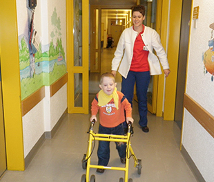 Junge mit Rollator und Knieorthesen