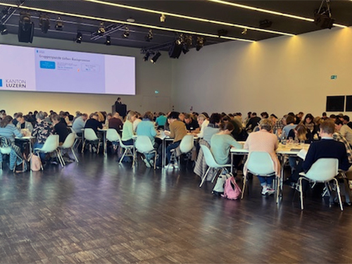 Bildungskommissionen sitzen zusammen an Tischen